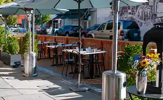 Thumbnail of picturesque scene for diners at Bistro Elan's parklet, enjoying a delightful meal surrounded by the lush greenery of Palo Alto.