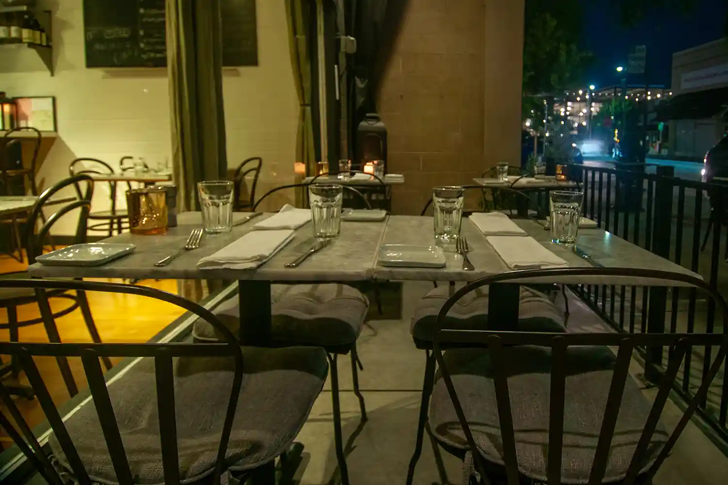 View of the cozy outdoor seating at Bistro Elan's patio, featuring elegant tables adorned with colorful blooms, perfect for al fresco dining in Silicon Valley.